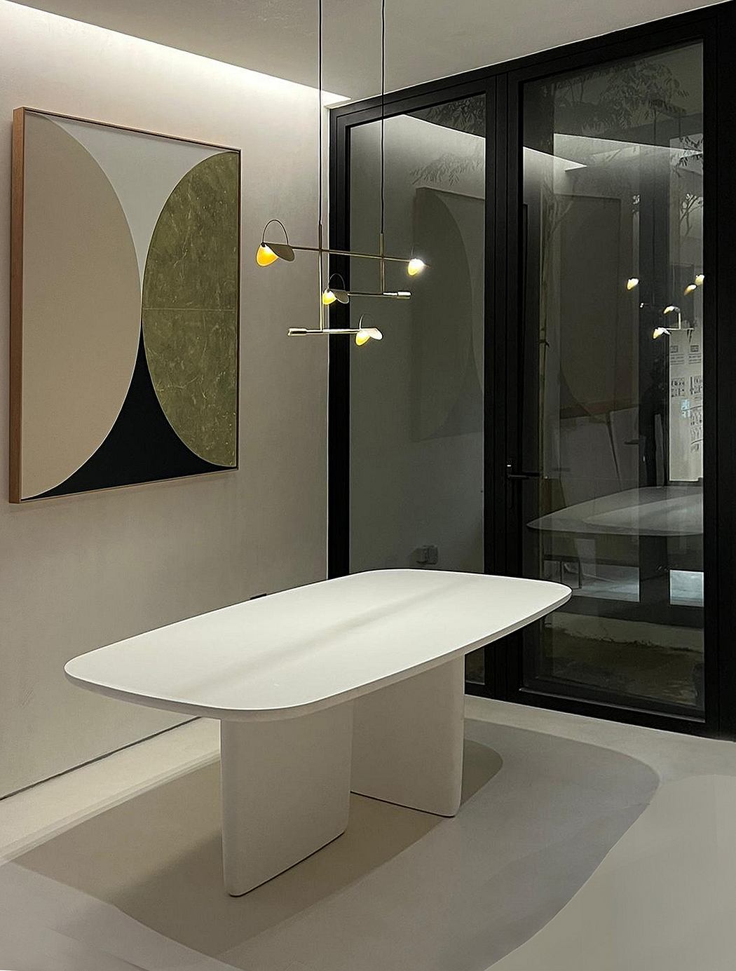 A minimalist interior design with a sleek white table, contemporary lighting, and geometric wall art.