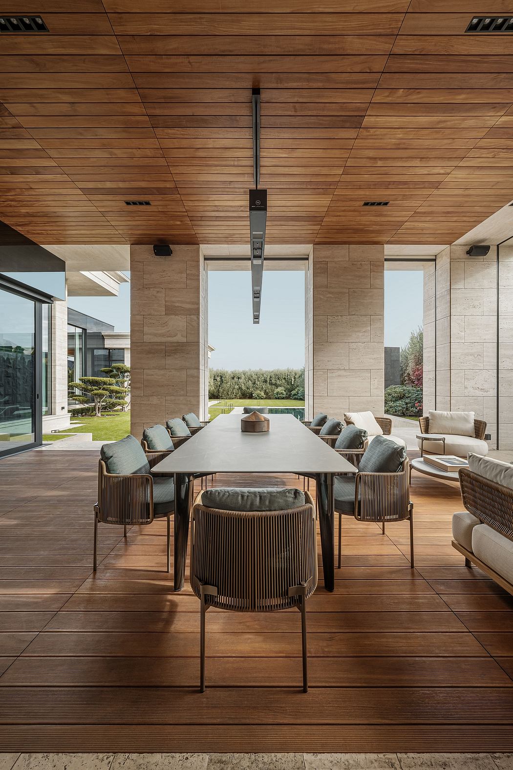 A sleek, contemporary dining area with a large wooden table, comfortable chairs, and a stunning view of a lush garden.