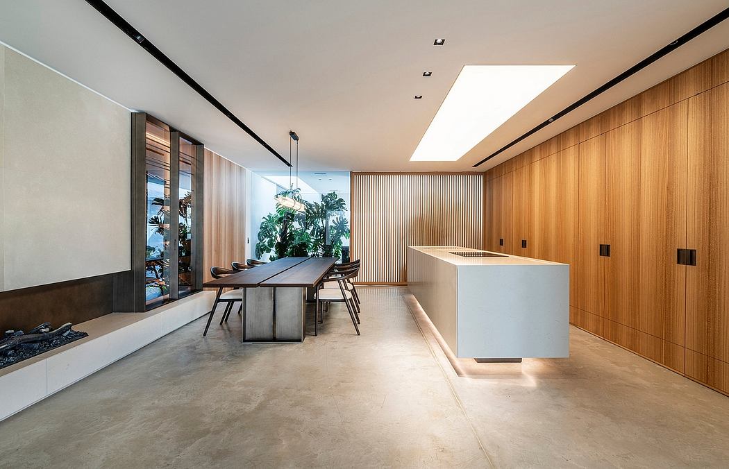 Modern and minimalist dining and kitchen area with wooden panels, concrete flooring, and a central island.
