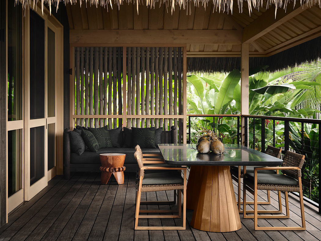 Cozy tropical patio with bamboo accents, plush seating, and a modern dining set overlooking lush vegetation.