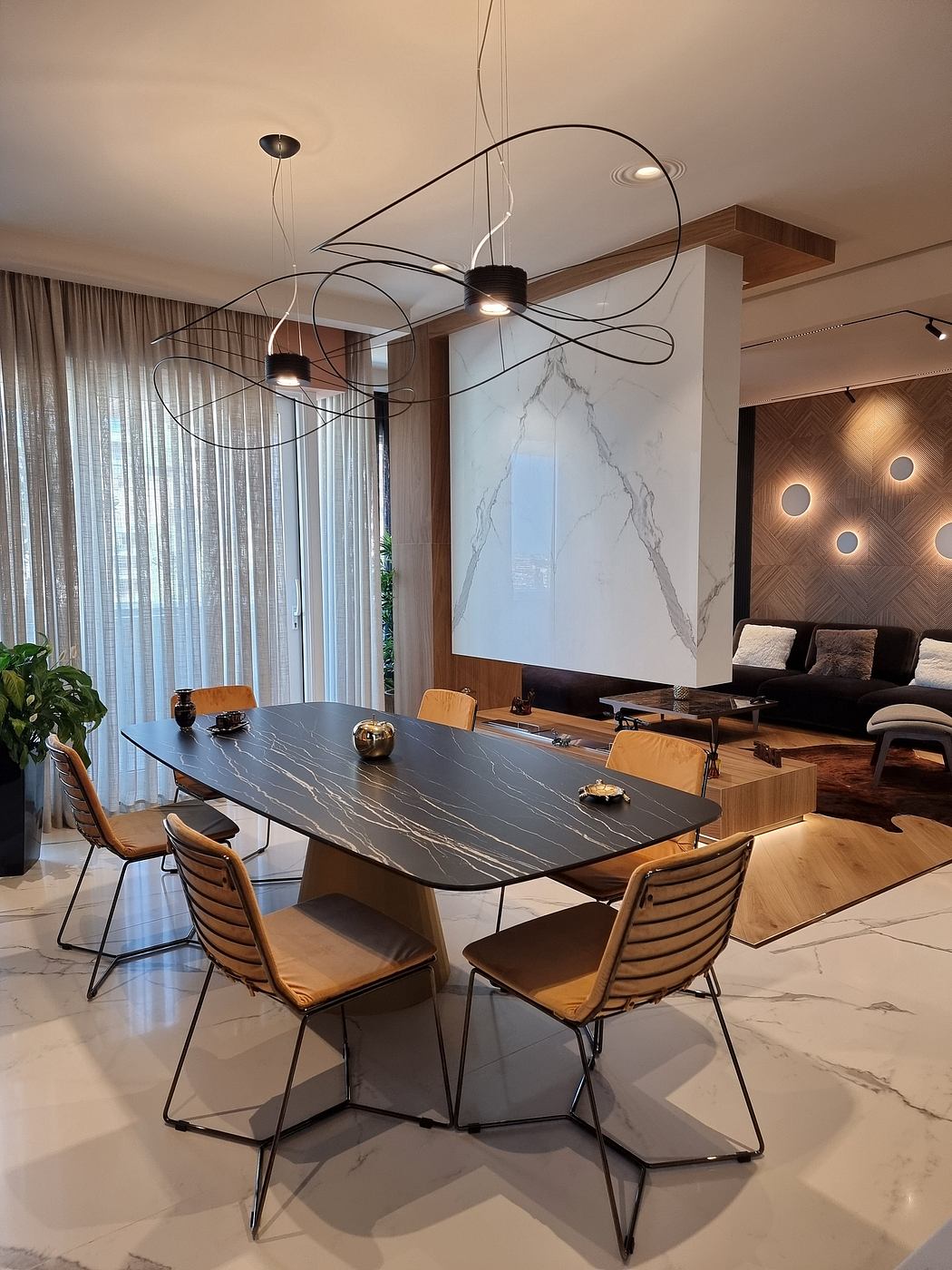Elegant dining room with sleek marble table, modern lighting fixture, and wooden accents.