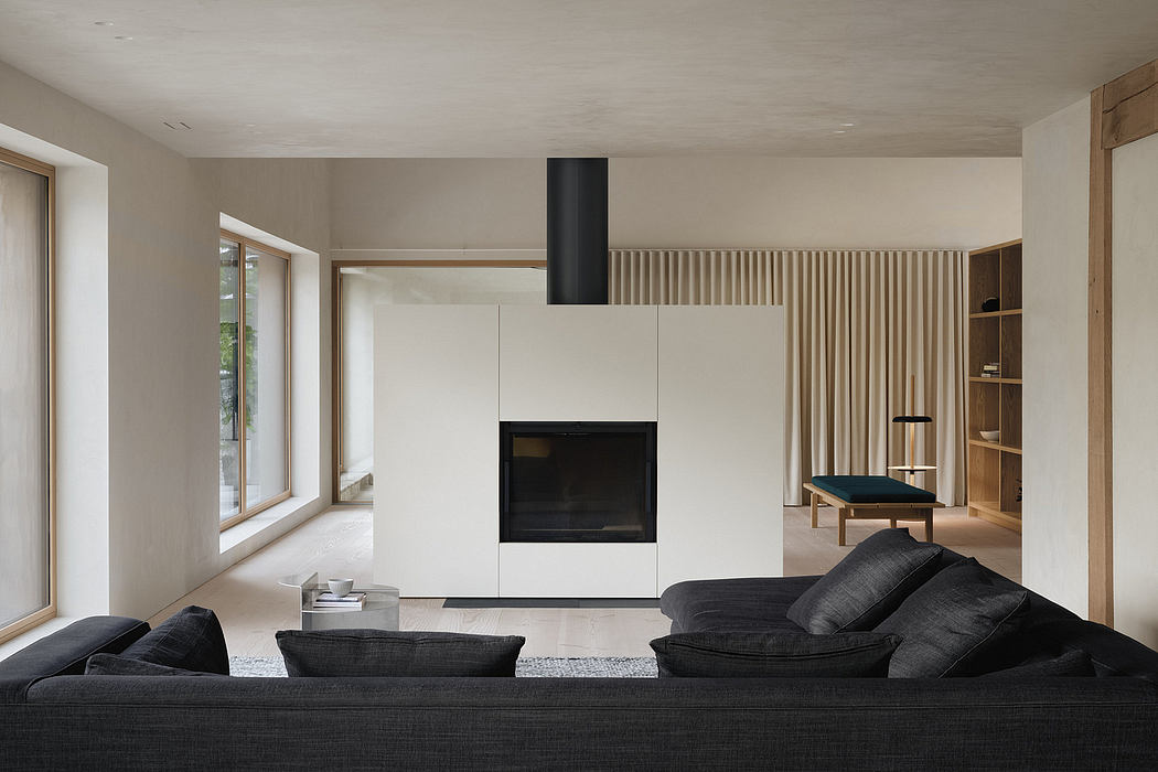 Minimalist living room with floor-to-ceiling windows, neutral tones, and sleek fireplace.