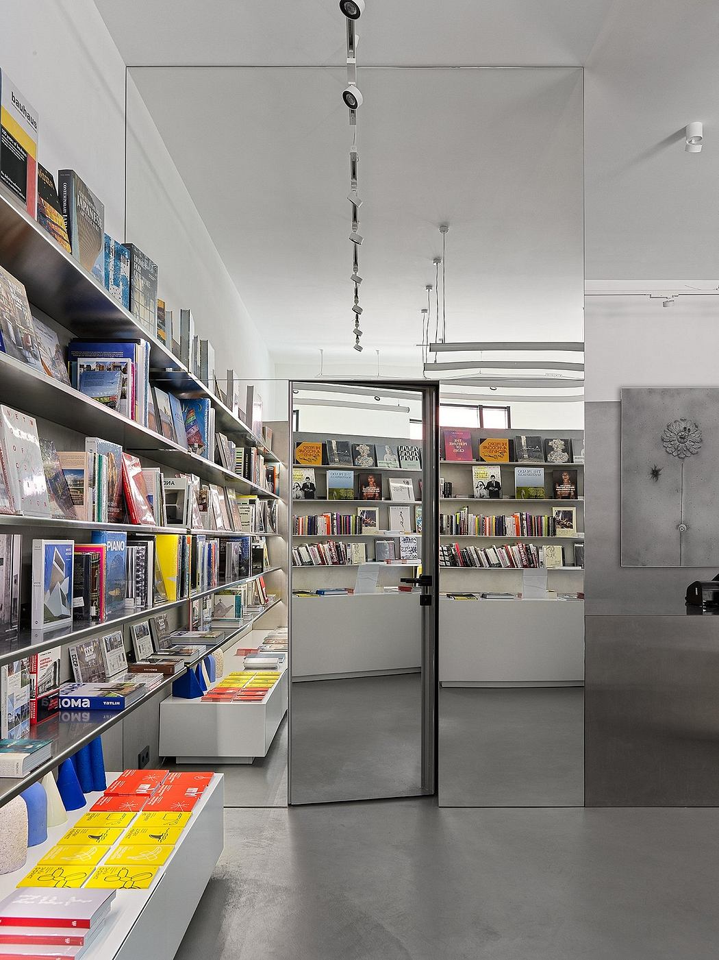 A modern, minimalist bookstore with sleek shelving, lighting, and a cohesive color palette.