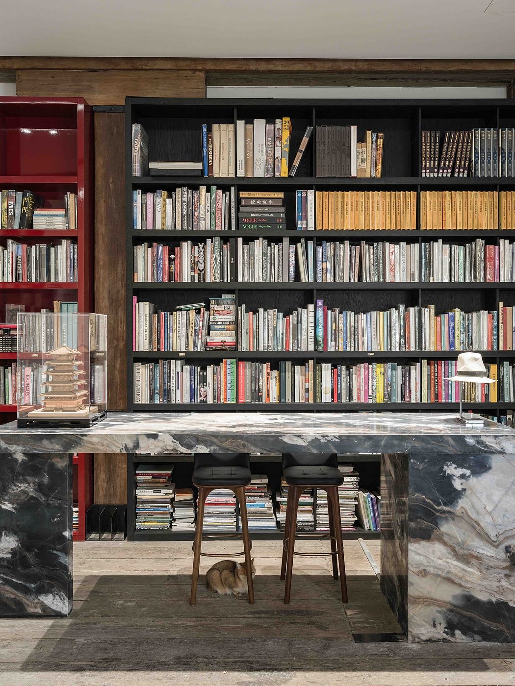 Ornate wooden bookshelves dominate the space, complemented by sleek marble countertops.