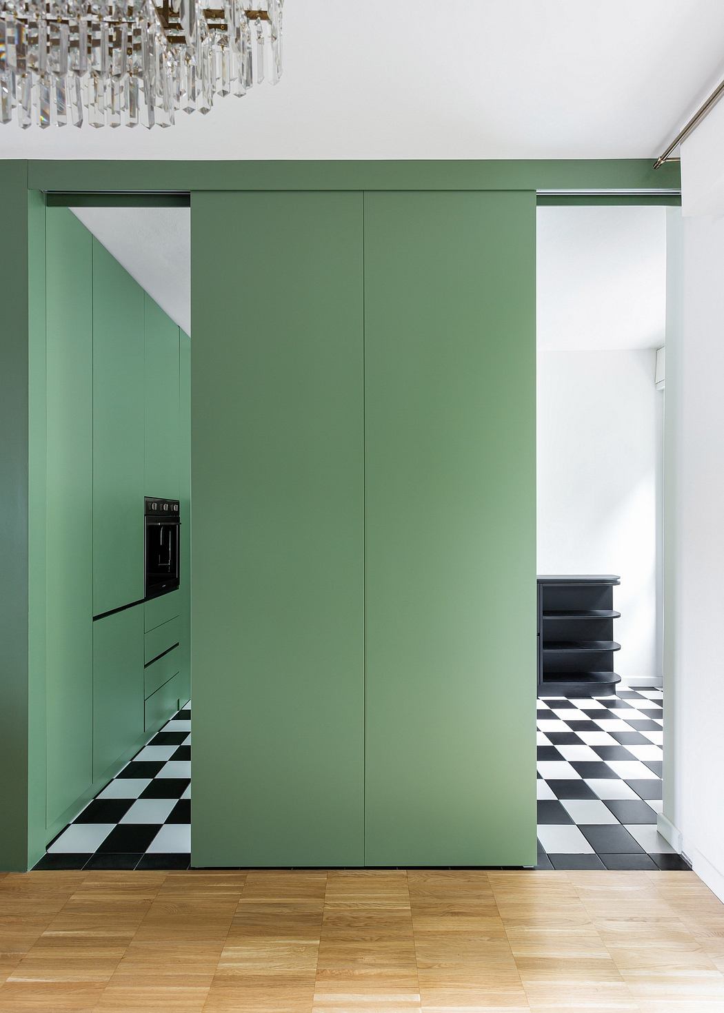 This interior features green cabinetry, black-and-white checkered flooring, and a crystal chandelier.
