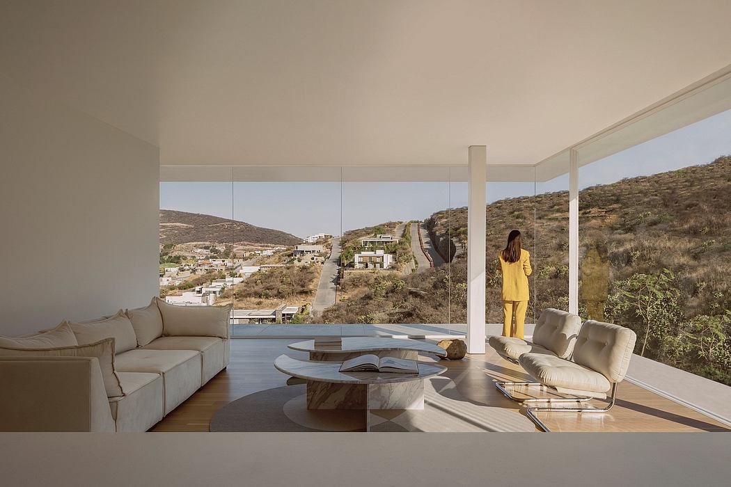 Modern living space with expansive glass walls, sleek furniture, and scenic mountain view.