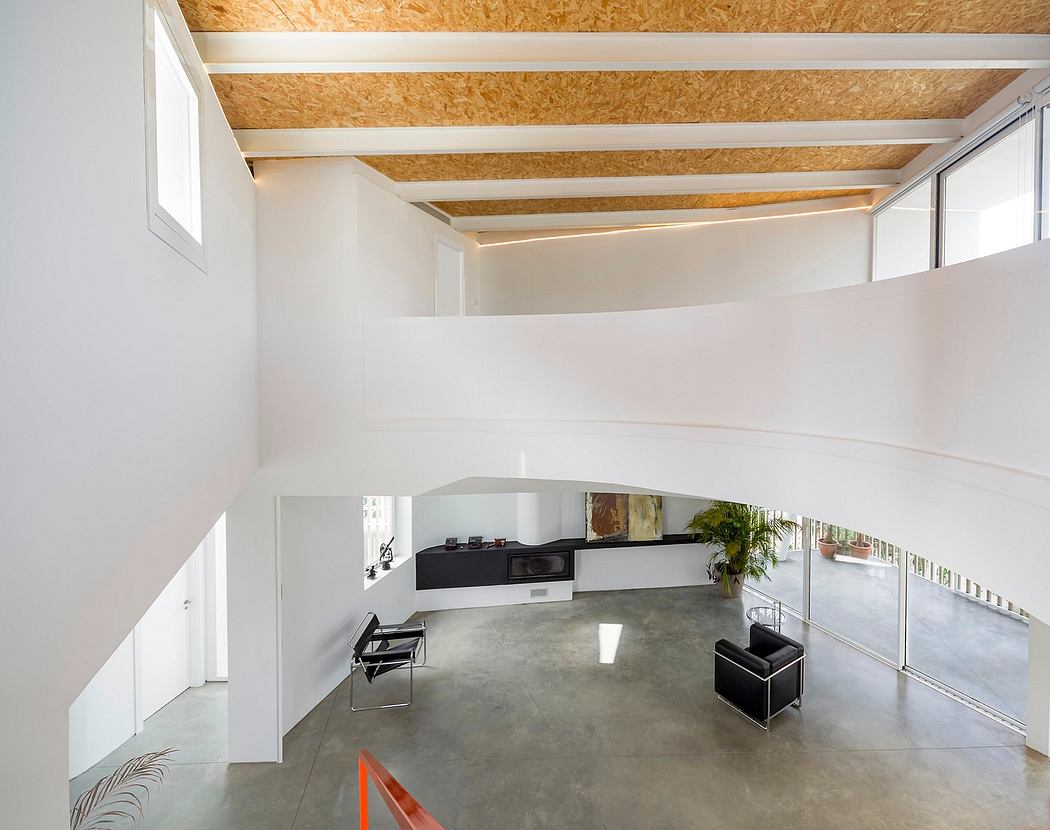 A modern, minimalist interior with exposed wooden beams, concrete floors, and glass walls.