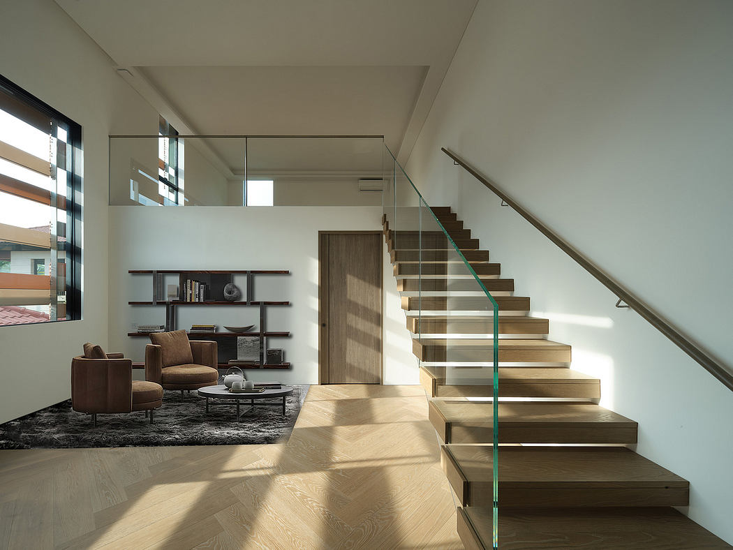 Modern open-concept living space with wooden stairs, glass railing, and minimalist furnishings.