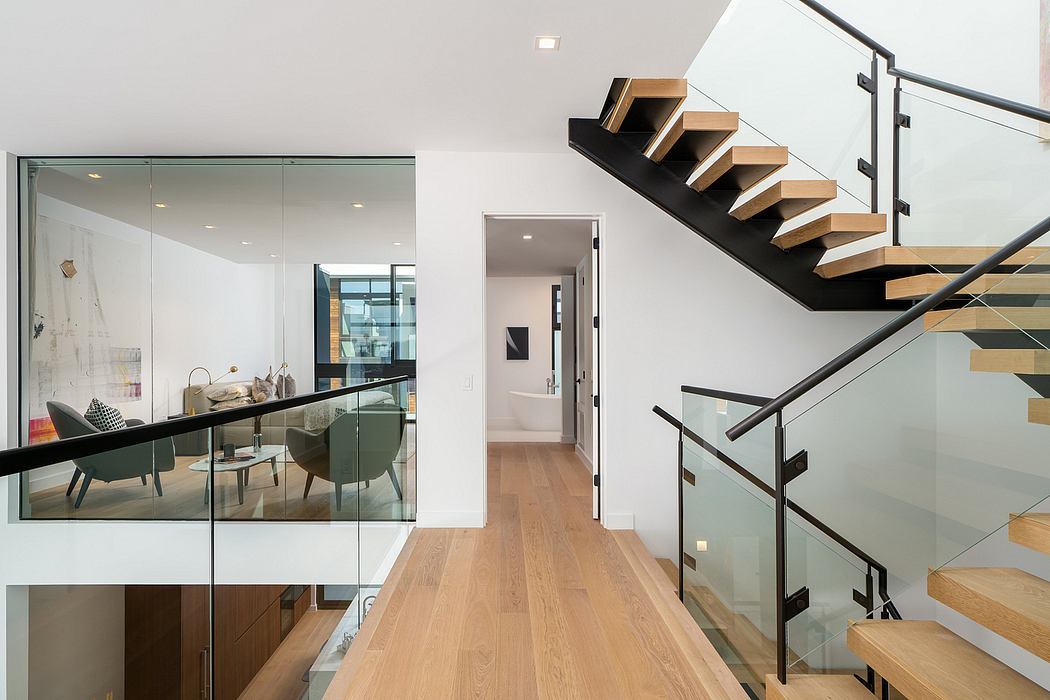 Sleek modern interior with floating wooden staircase, glass walls, and minimalist decor.