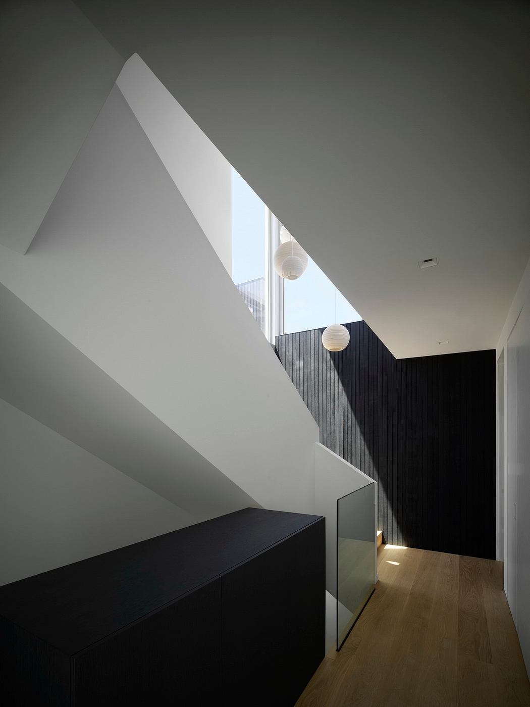 A stark, minimalist interior with angular architectural forms and geometric shapes.