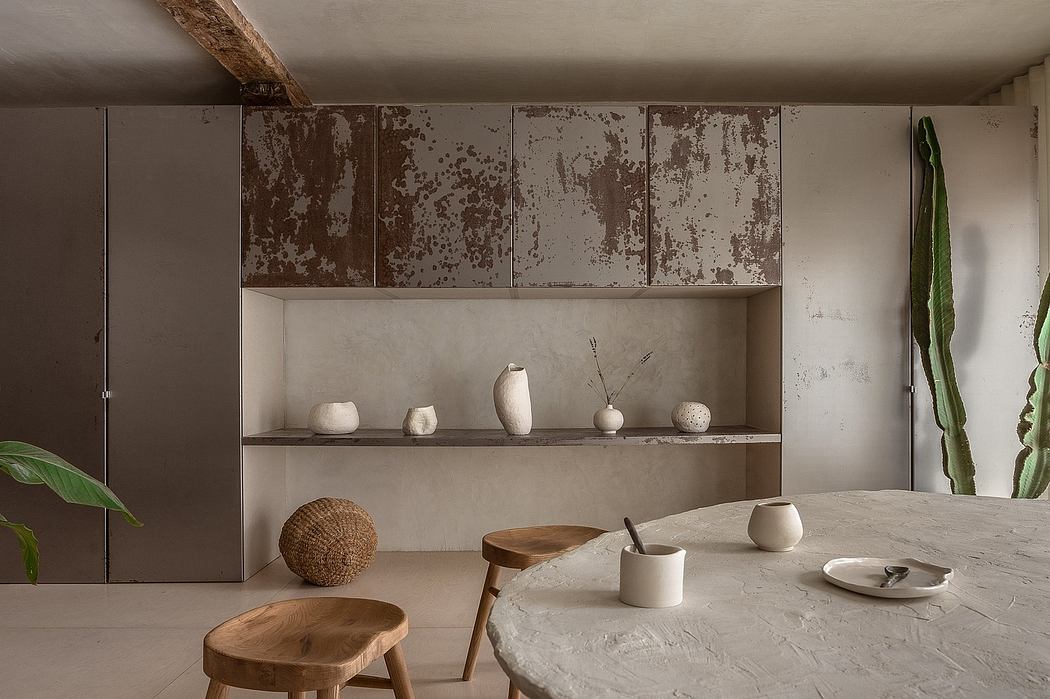 Rustic kitchen interior with weathered cabinets, wooden stools, and natural decor.
