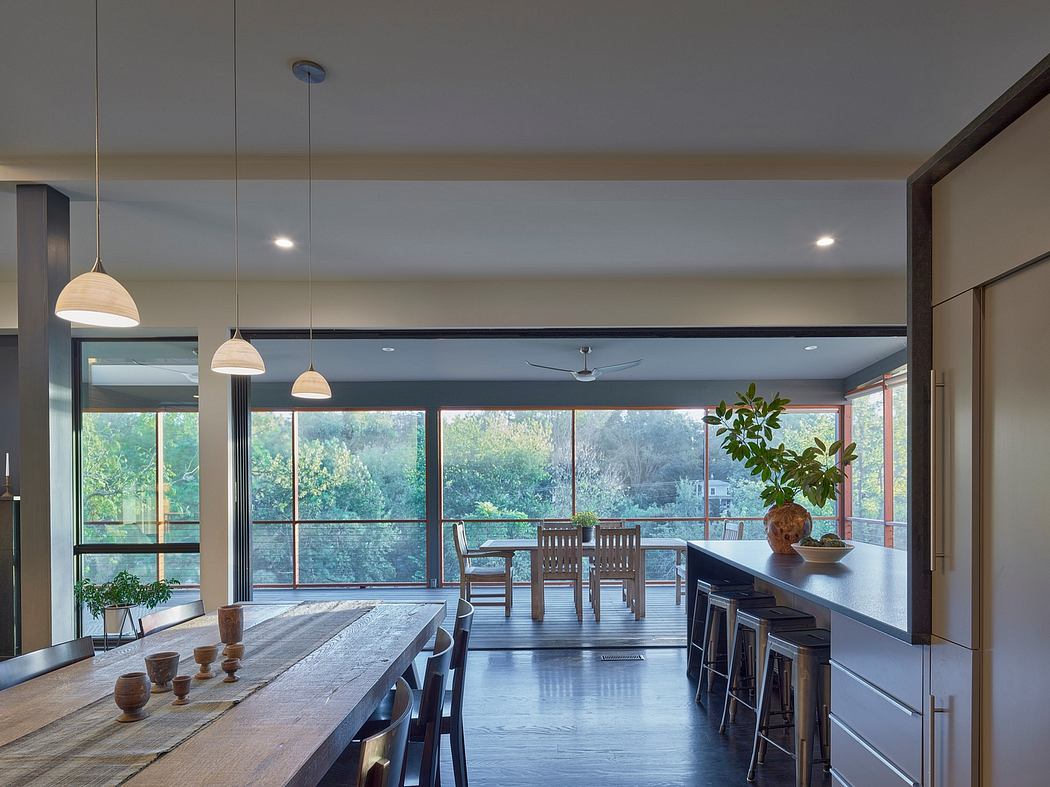 Spacious open-concept dining room featuring large windows, wood accents, and modern lighting.