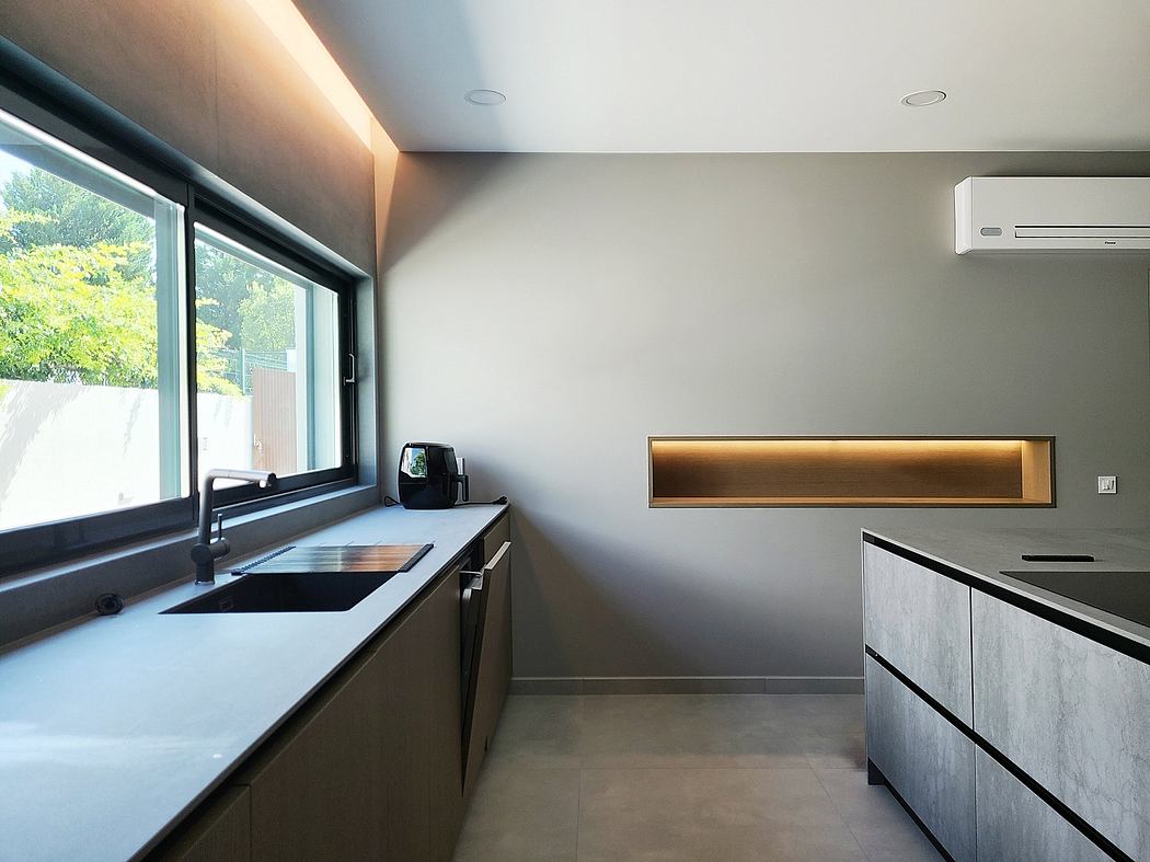 Sleek, minimalist kitchen with clean lines, recessed lighting, and a large window offering views.