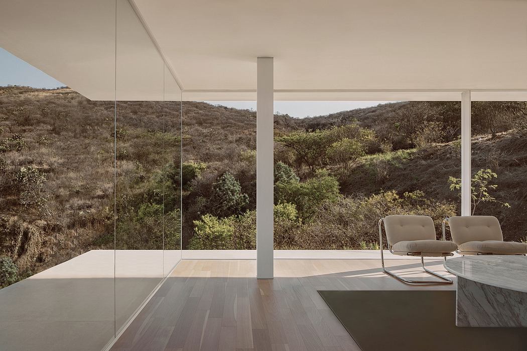 Expansive glass walls frame a serene hillside vista, accentuated by modern design elements.