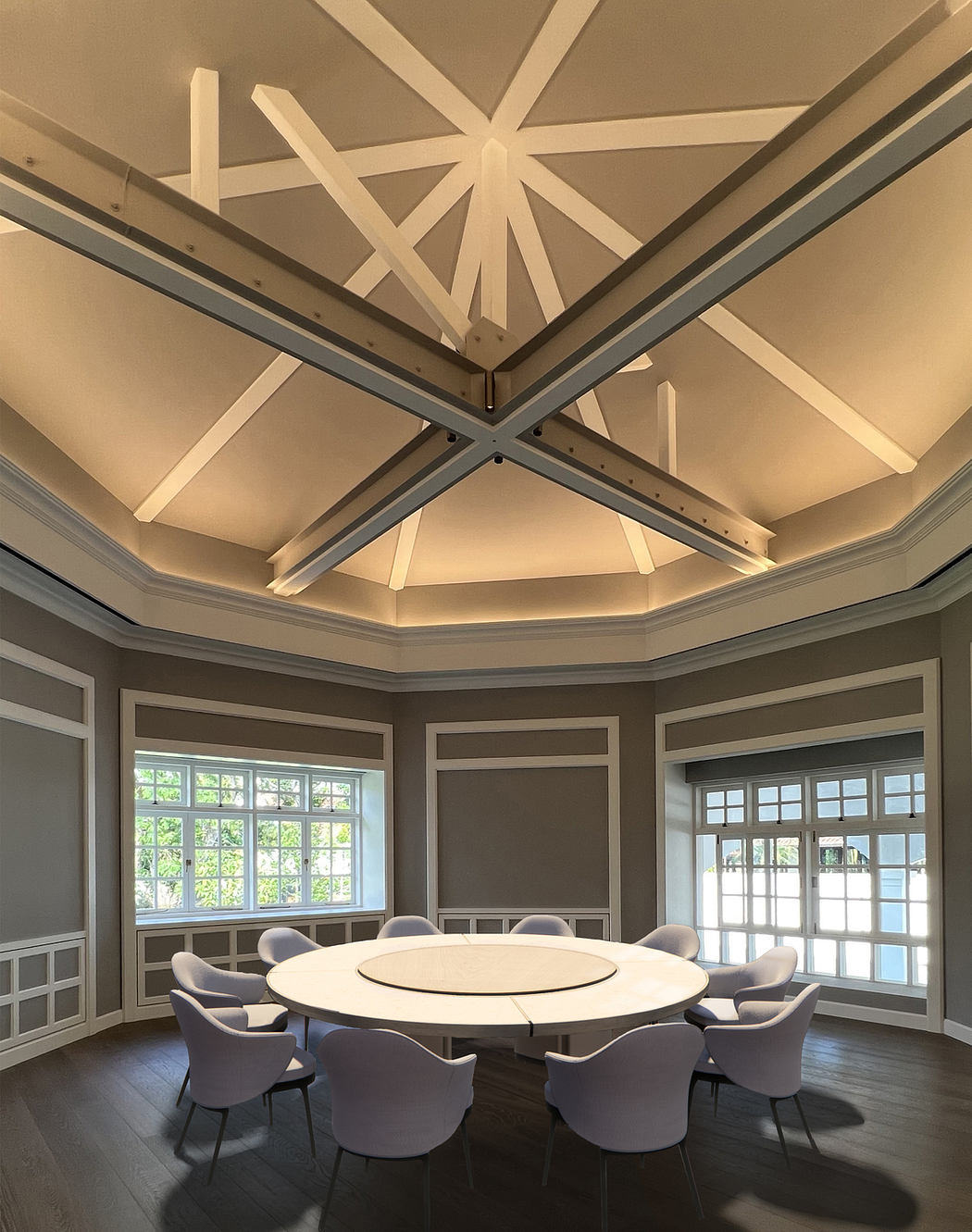 A spacious room with an intricate, octagonal ceiling design and large windows.