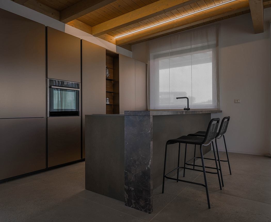 Dark-toned modern kitchen with wooden ceiling beams, slate-gray island, and minimalist black bar stools.