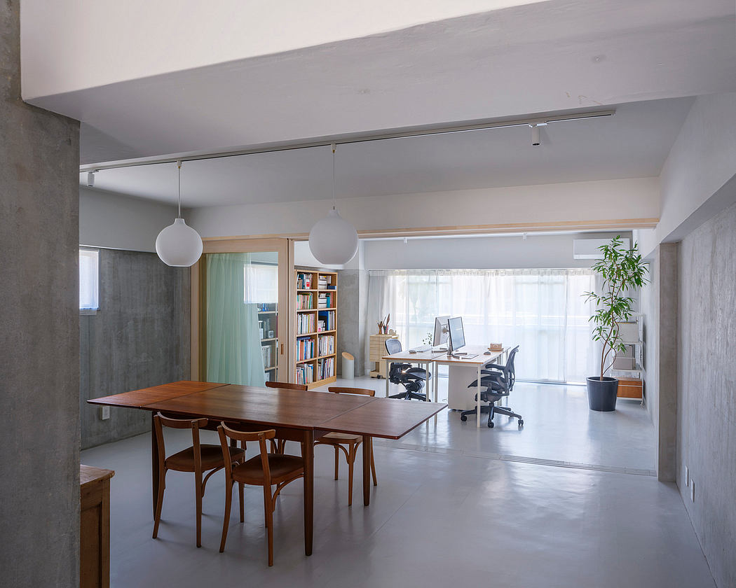 Modern open-concept interior with minimalist design, wooden furniture, and bookshelves.