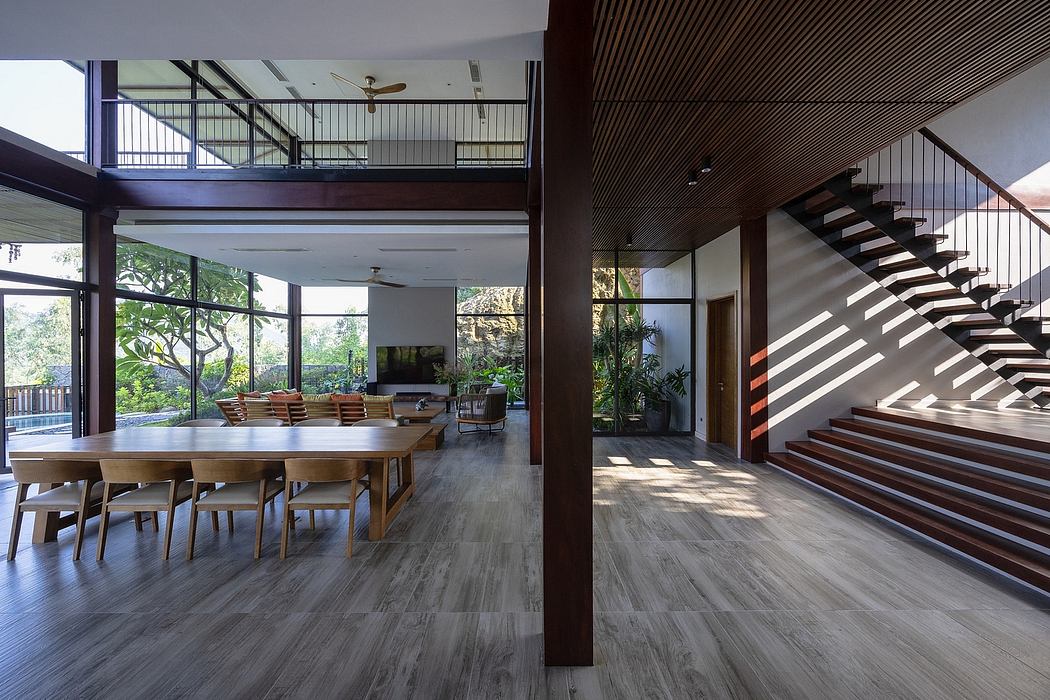 Expansive open-concept living space with wooden beams, stairs, and contemporary furnishings.