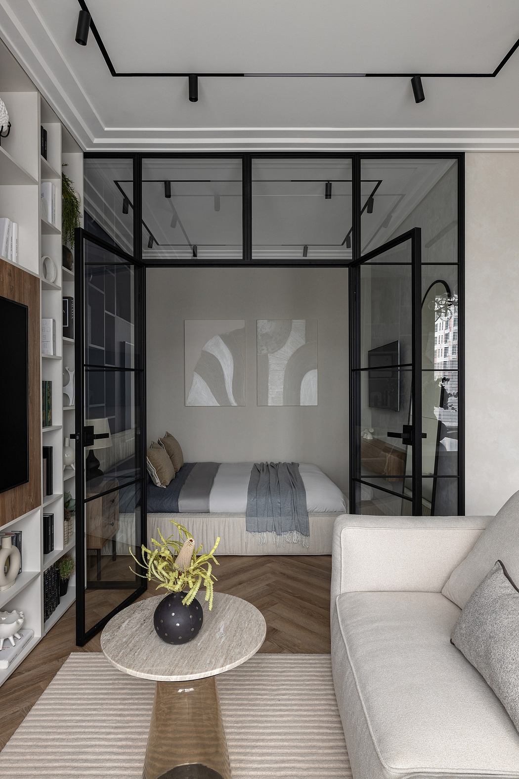 Modern studio apartment with glass-enclosed bedroom, sleek black metal frames, and minimalist decor.