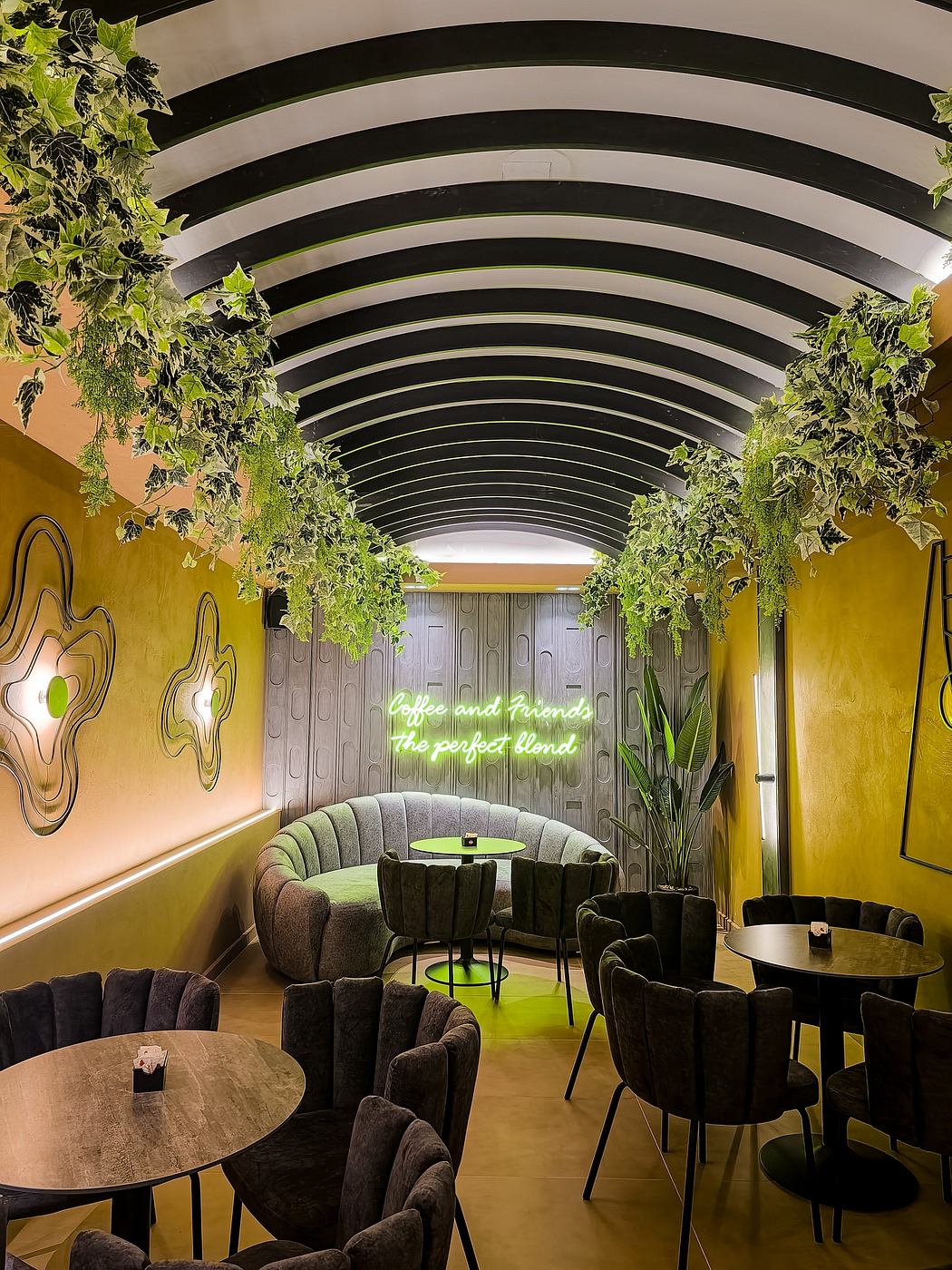 A vibrant, arched cafe interior with lush greenery, curved seating, and neon signage.