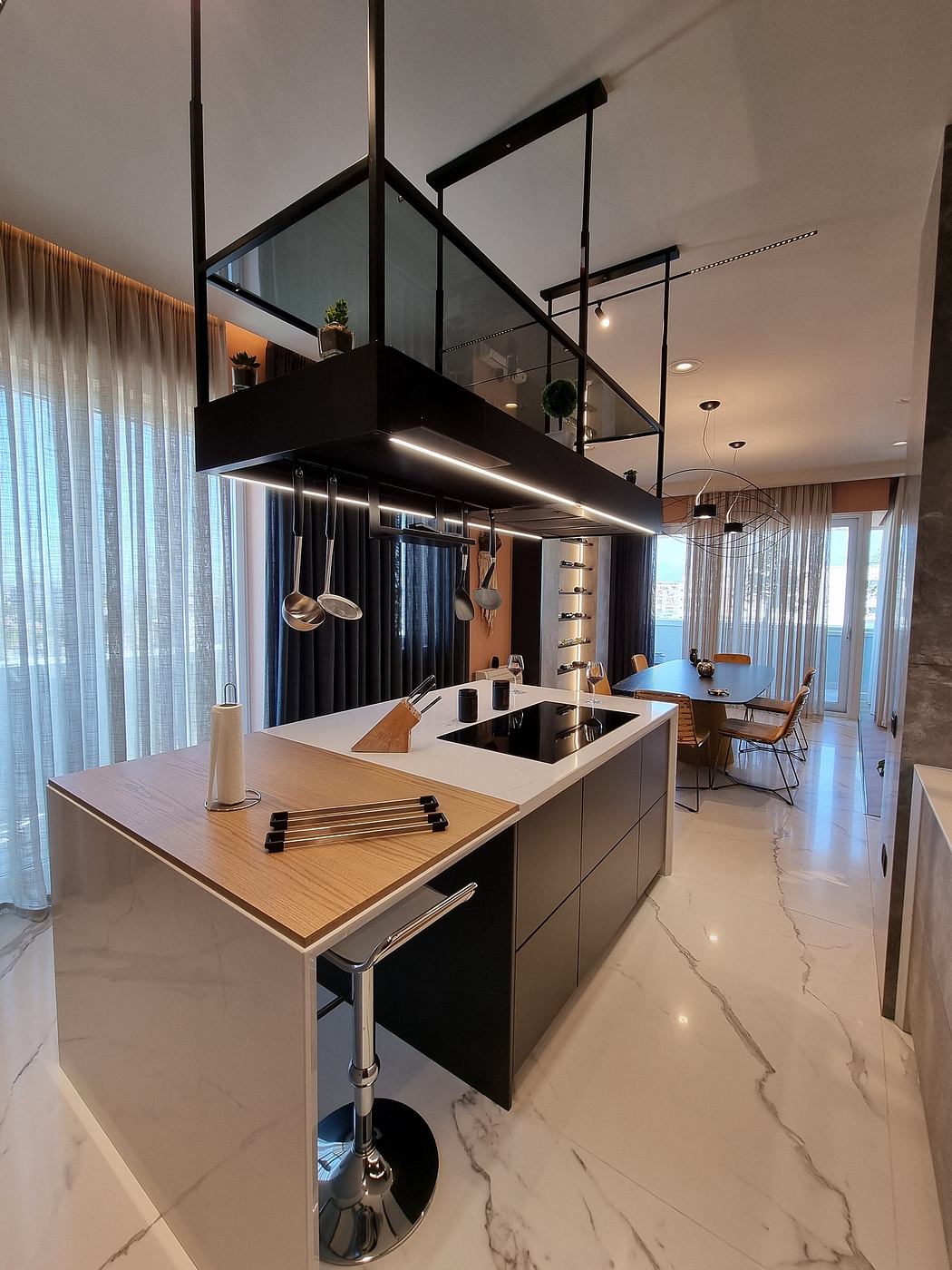 Sleek, modern kitchen with black fixtures, wood accents, and a marble-tiled floor.