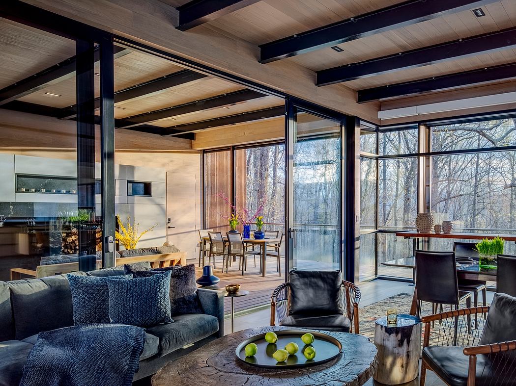 Expansive room with wooden beams, large windows, cozy seating, and modern furnishings.
