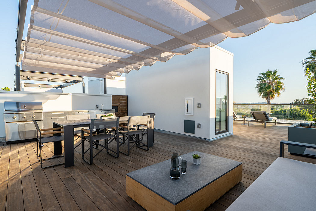 A modern outdoor living space with a covered terrace, dining area, and kitchen appliances.