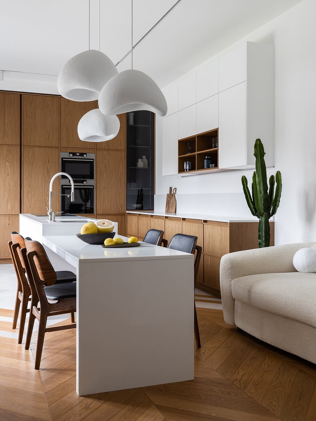 Modern open-concept kitchen with wooden cabinetry, white countertop, and pendant lamps.