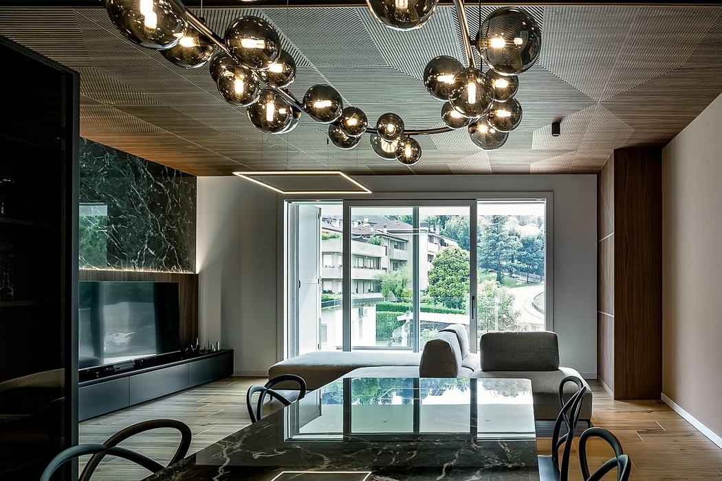 Sleek, modern interior with a striking lighting fixture, marble accents, and expansive windows.