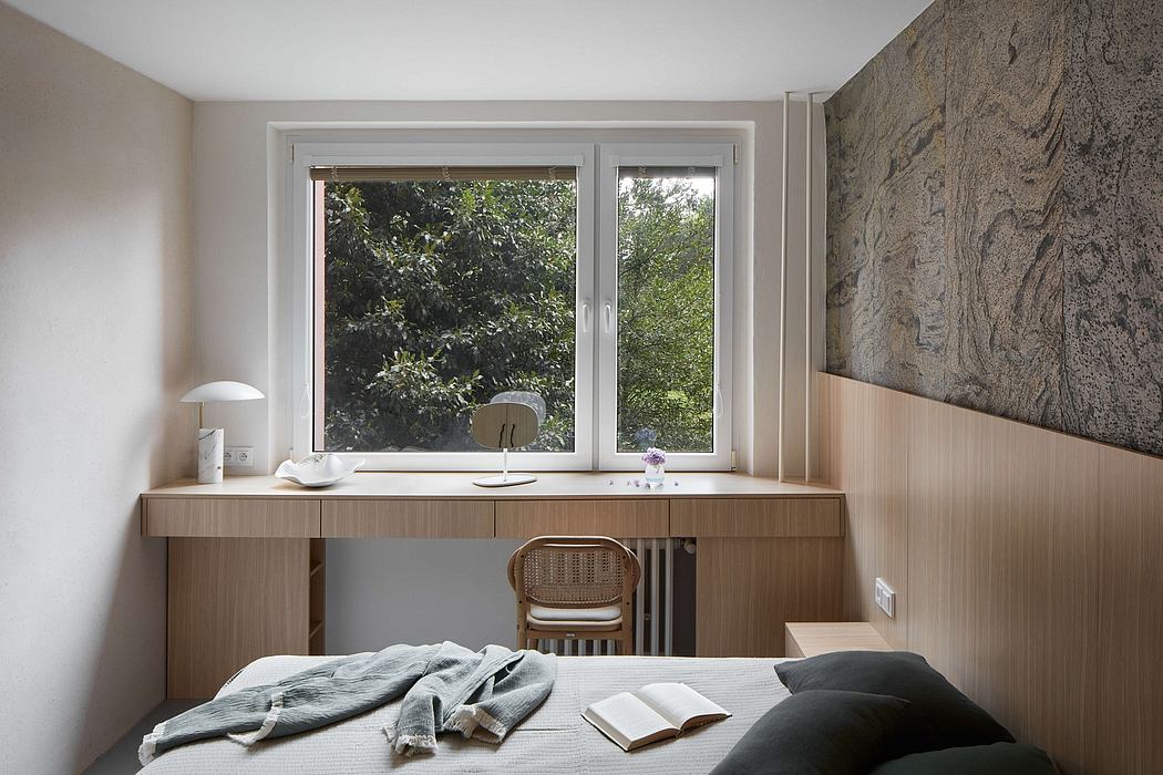 Minimal modern bedroom with wooden desk, large window, and neutral color palette.
