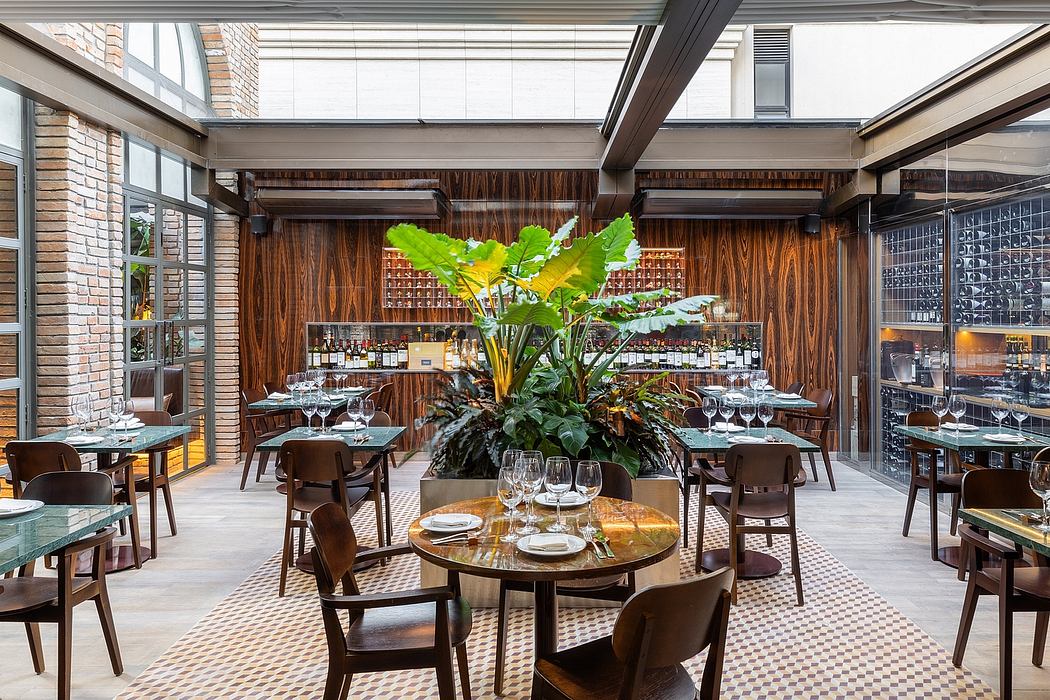 A cozy, contemporary restaurant interior with wooden accents, greenery, and glass walls.