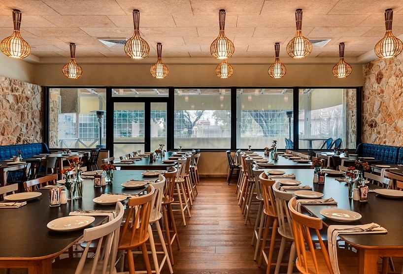 A cozy restaurant interior with warm lighting, wooden furniture, and natural stone walls.