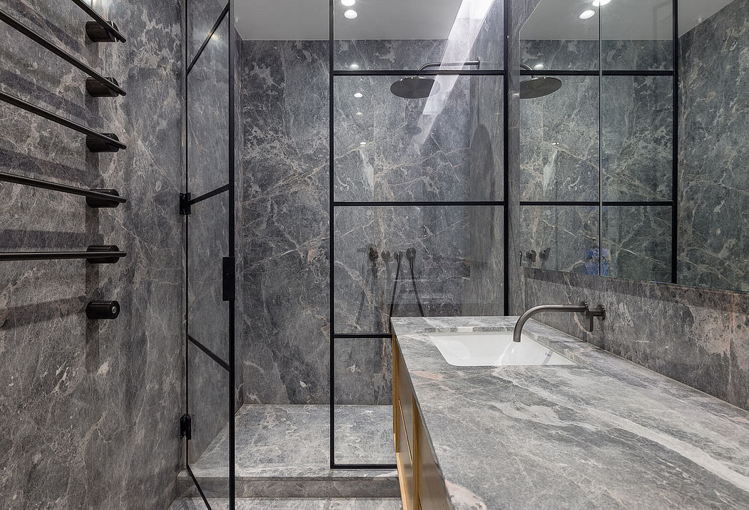 A modern bathroom with gray marble walls, shelves, and a counter with a minimalist sink.
