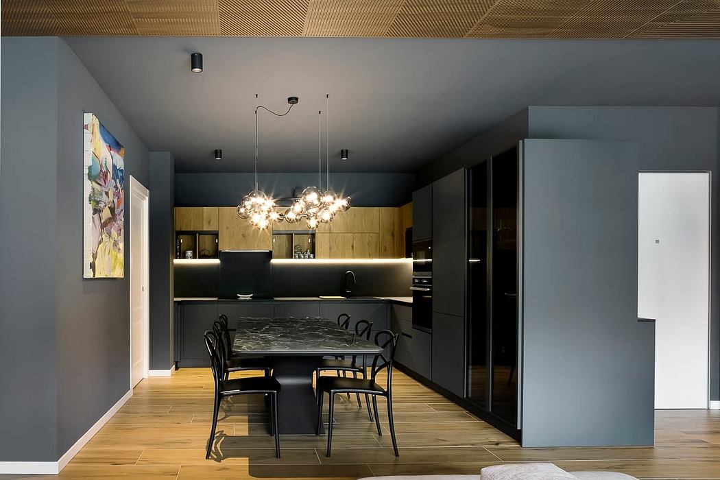 Sleek, modern kitchen with glossy black cabinetry, statement lighting, and wood flooring.