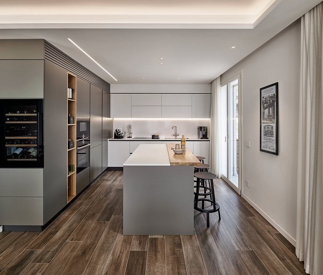 Modern kitchen with sleek cabinetry, wood floors, and a central island with bar stools.