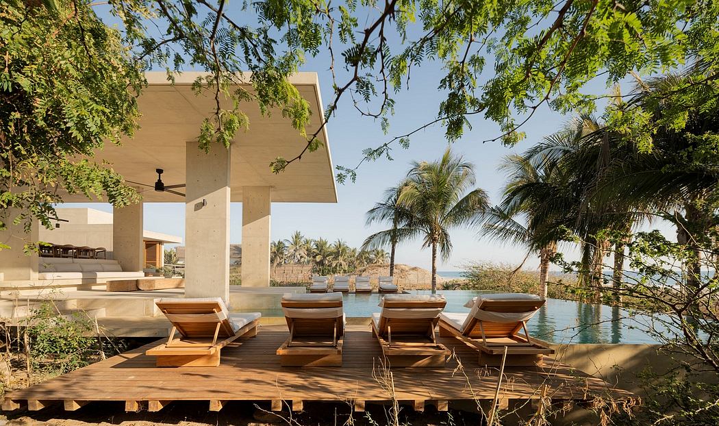 Serene tropical resort pool deck with wooden chaise lounges and palm trees framing the view.