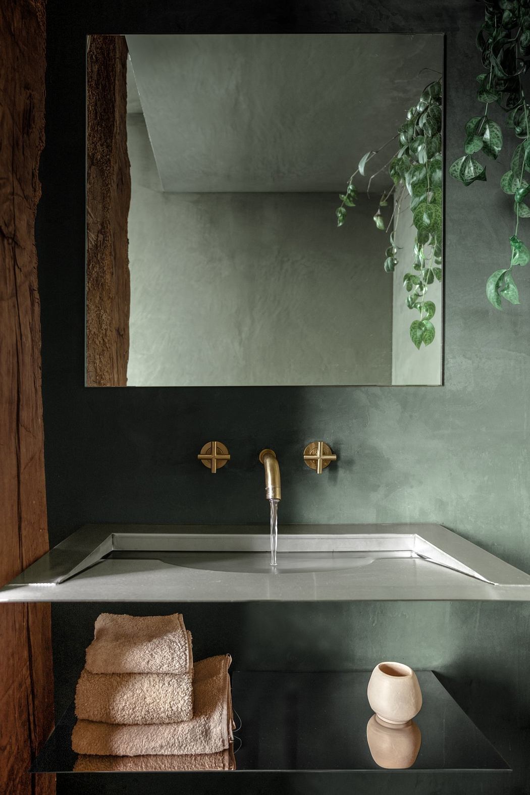 A minimalist bathroom with a geometric mirror, brass fixtures, and a sleek vanity.