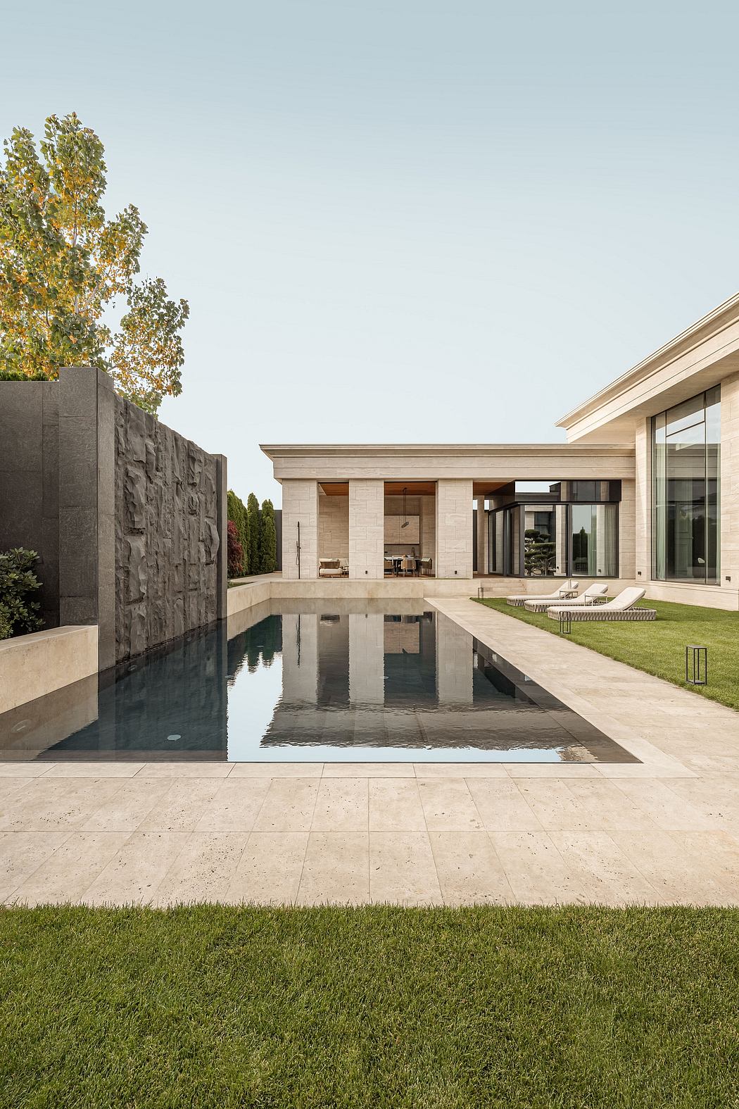 Modern architectural design with a reflection pool, glass walls, and landscaped garden.