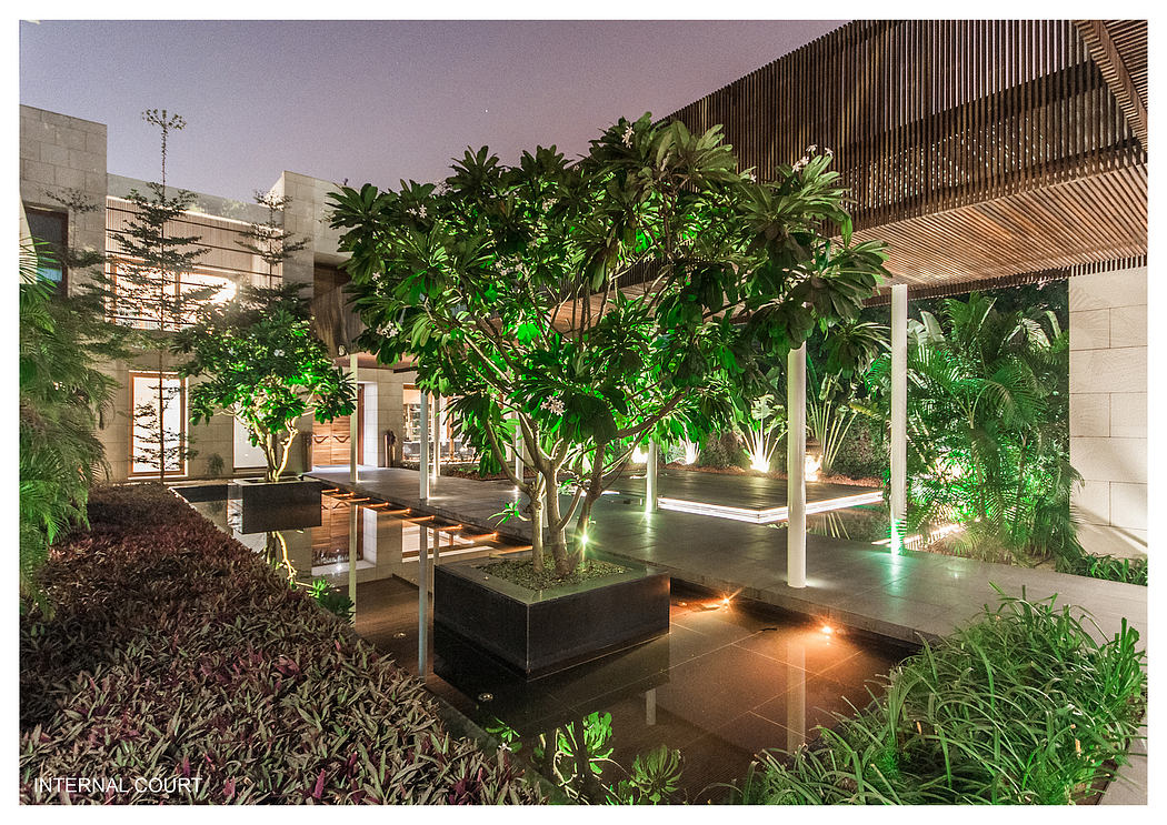 Lush, verdant interior courtyard with a grand tree, reflecting pool, and modern architectural details.