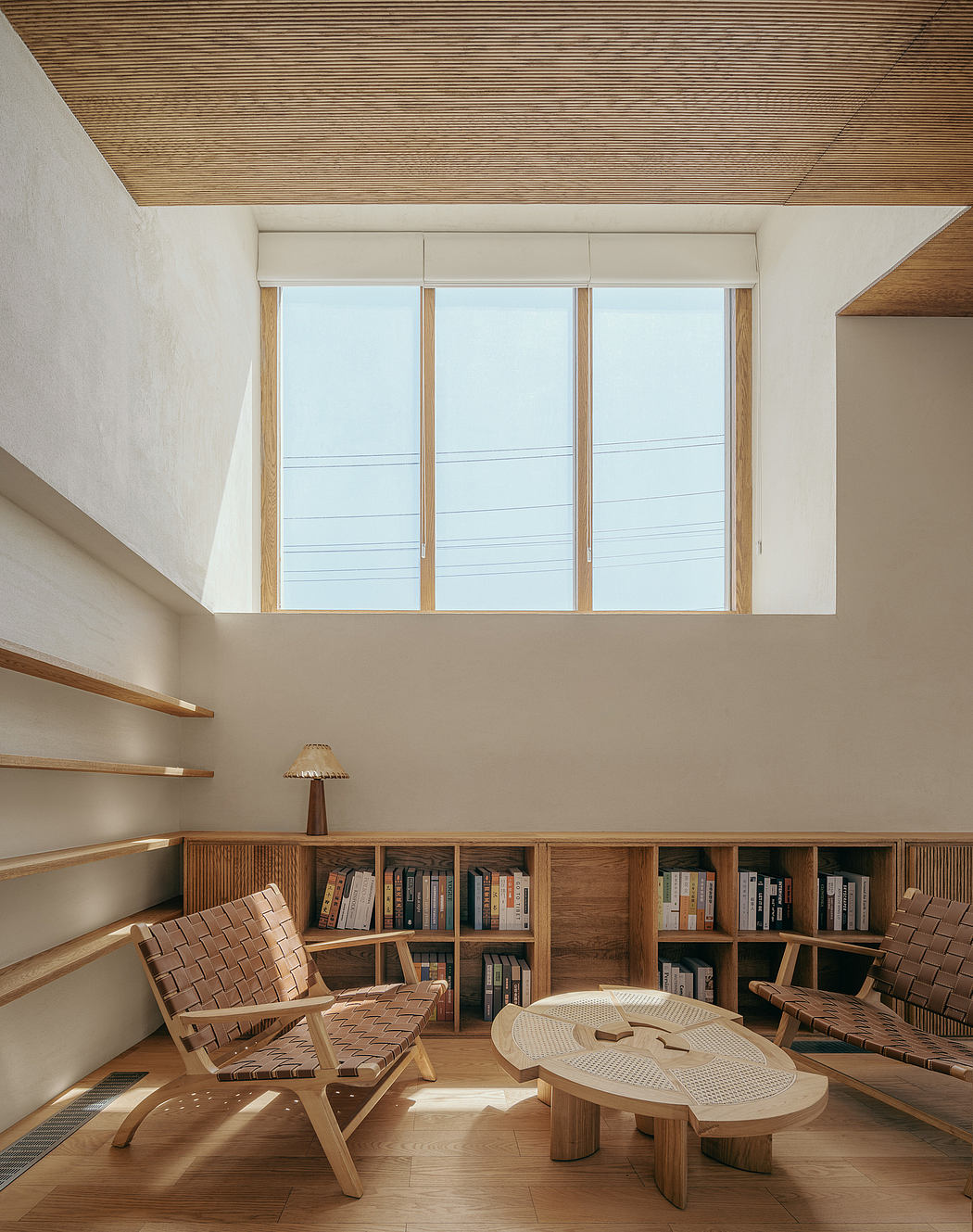 Bright, airy living space with wood-clad ceiling, shelves, and furnishings.