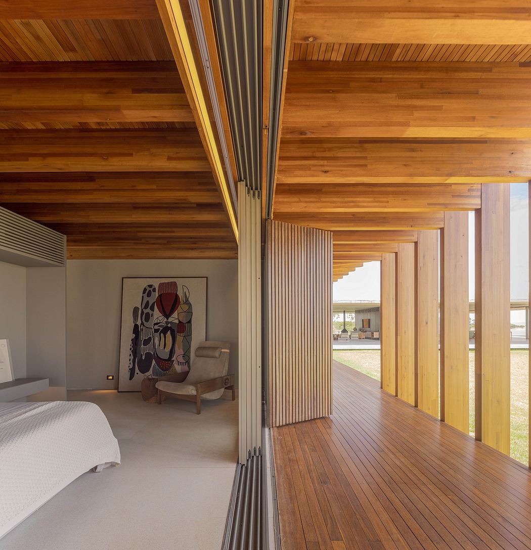 A spacious bedroom with a wooden ceiling and floor, accented by a modern abstract artwork.