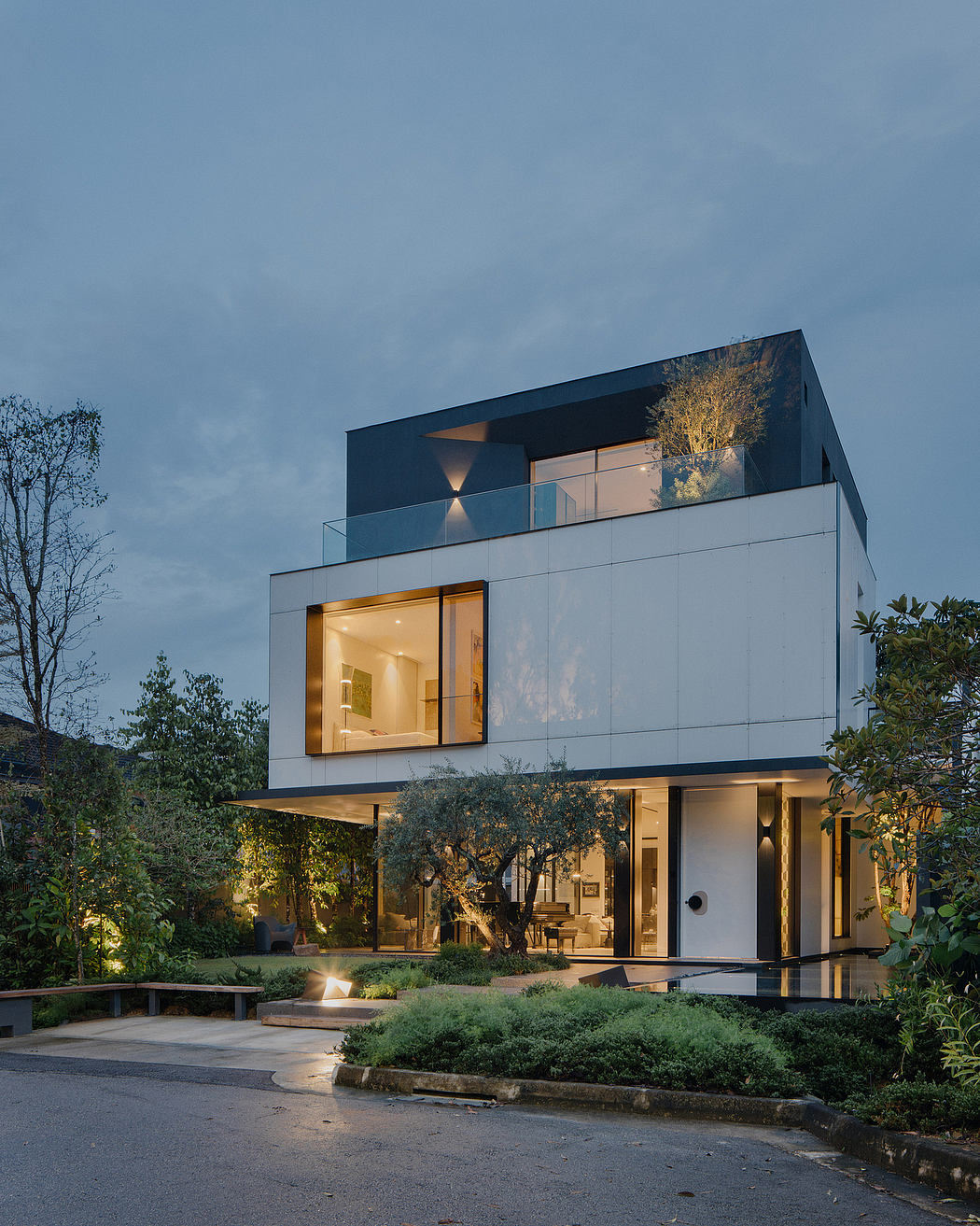 This modern home features a sleek black-and-glass design, with a balcony surrounded by greenery.