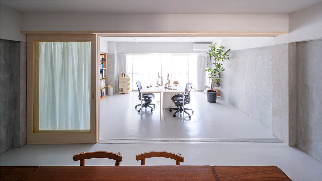 Spacious modern office with minimalist design, large windows, and wooden furniture.