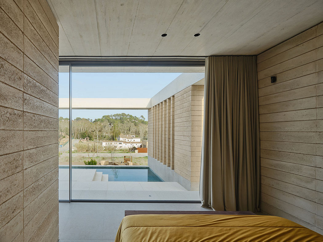 Spacious bedroom with large windows offering scenic outdoor views and a swimming pool.