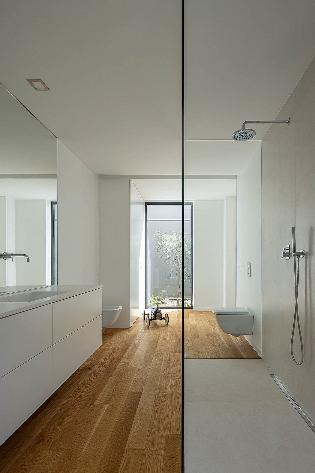 Sleek, minimalist bathroom design with large window, wooden floors, and modern fixtures.