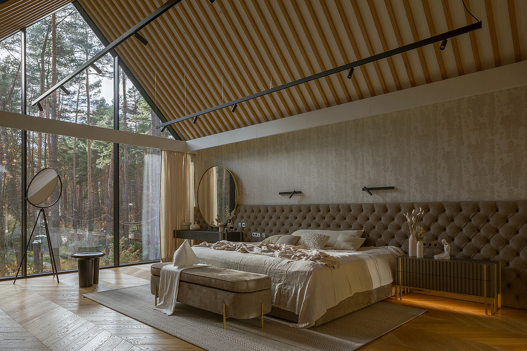 A cozy bedroom with large windows, wooden ceiling, and a tufted beige headboard.
