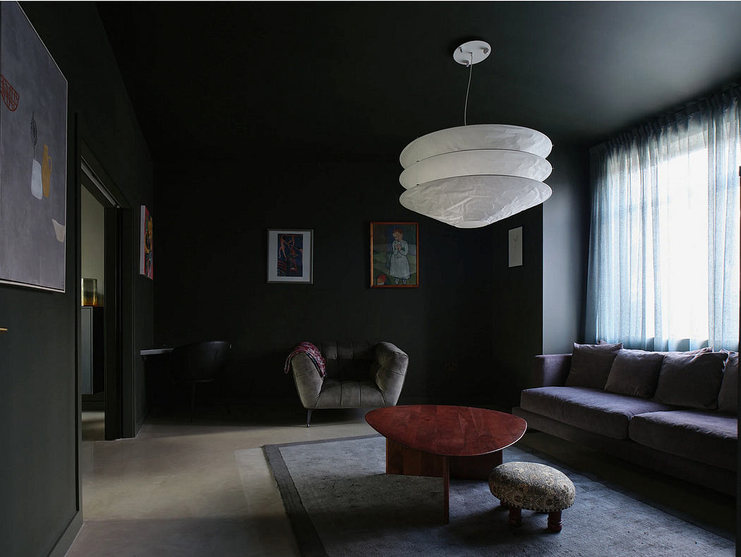 Moody living room with abstract art, plush seating, and a modern lighting fixture.