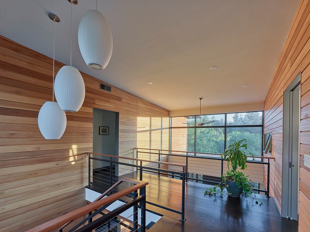 Warm wooden walls, modern pendant lights, and a balcony with views in this sleek interior.