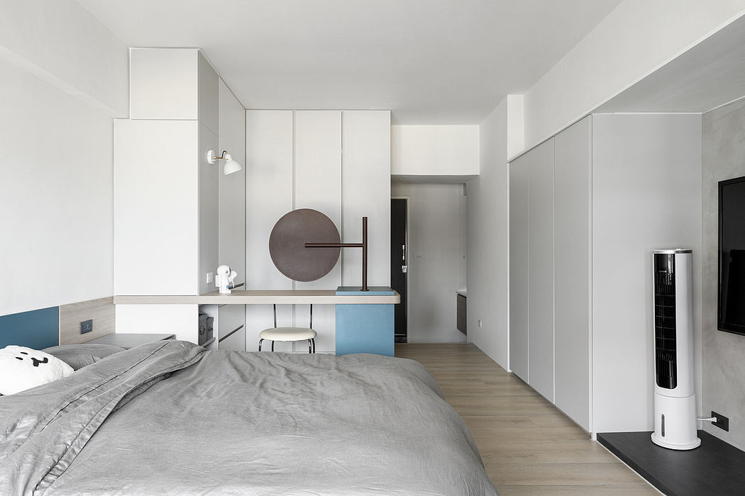 Minimalist bedroom with built-in storage, desk, and modern decor elements.