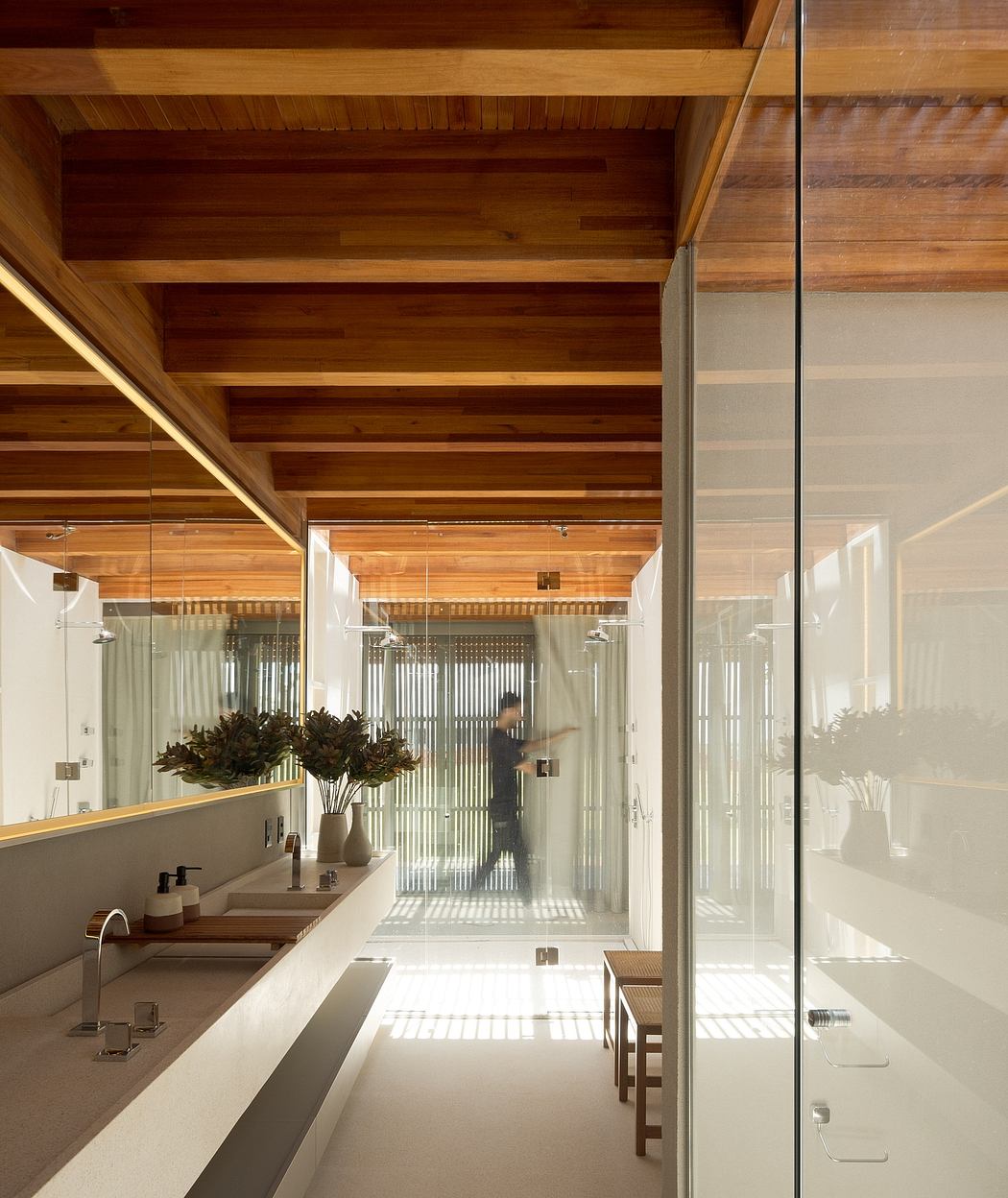 Warm, wooden ceiling beams and sleek glass walls create a modern, open interior design.